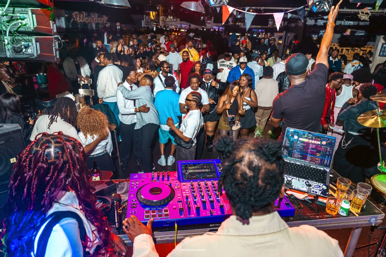 A packed BykonzYard dancefloor seen from behind the decks