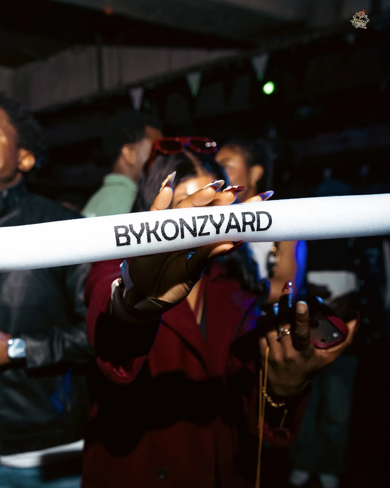 A BykonzYard lightstick held up on the dancefloor